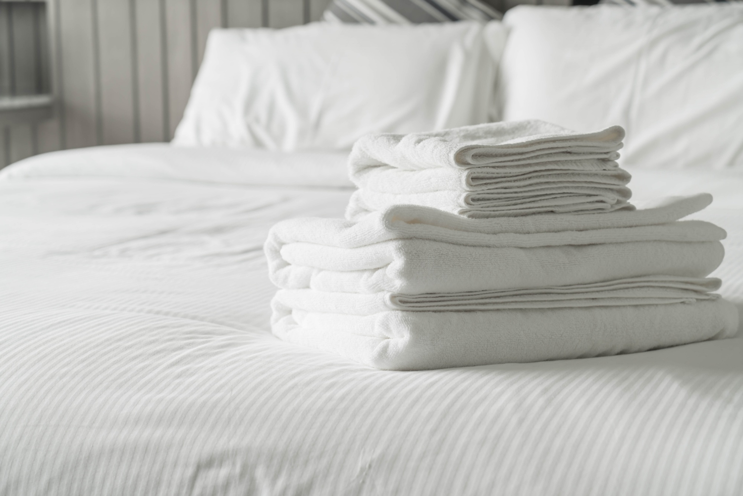 Des serviettes blanches sont posées sur un lit.